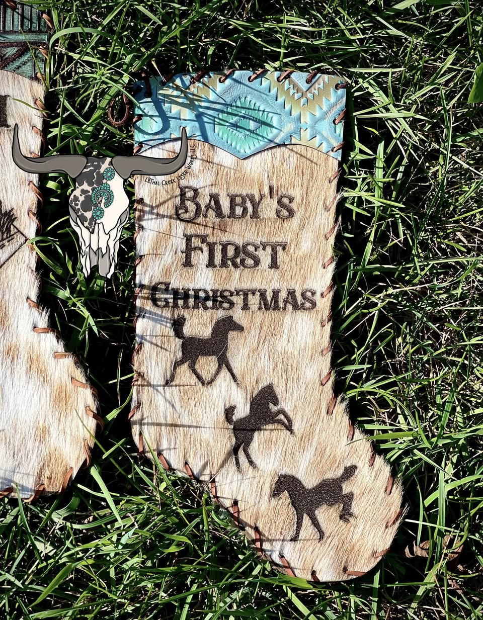 A rustic wooden Christmas stocking sign with the engraved text 'Baby's First Christmas' and silhouettes of three horses.